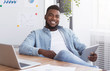 © Prostock-studio - Portrait of cheerful black employee with digital tablet at workplace