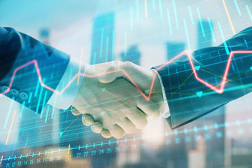 Double exposure of financial graph on cityscape background with two businessman handshake. Concept of stock market deal