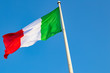 The Italian flag in the wind blue sky in the background