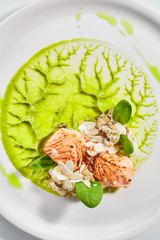 Wall Mural - Salmon steak on plate top view. Red fish piece with green pea puree and cauliflower. Tuna with creamy sauce and vegetables isolated on white background. Restaurant tasty dish, cooked healthy meal