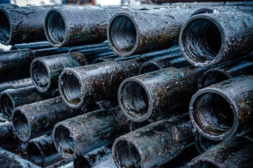 Wall Mural - Oil Drill pipe. Rusty drill pipes were drilled in the well section. Downhole drilling rig. Laying the pipe on the deck. View of the shell of drill pipes laid in courtyard of the oil and gas warehouse.