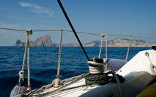Bow Of Sailboat With Windlass And Cape In First Term The Island Of Es Verá Ibiza In The Background