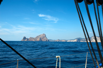 port of sailboat with nautical ends in first term the island of es verá ibiza in the background