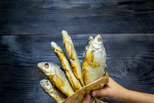 Man's Hands Hold A Paper Bag With Dried Fish