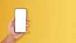 © piotrszczepanek - Smartfon, telefon w męskiej dłoni na żółtym tle