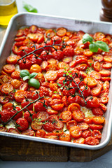 Wall Mural - Cherry tomatoes roasted with garlic and spices on a baking tray