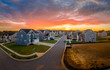 © tamas - Aerial view of new construction cul-de-sac street with luxury houses in a Maryland upper middle class neighborhood American real estate development in the USA with stunning sunset orange color sky
