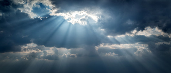 Panoramic view of clouds and sun with beautiful rays against the sky.