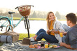© New Africa - Happy young couple having picnic near lake on sunny day