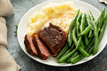 Traditional Dinner Meal With A Bacon Wrapped Steak, Green Beans And Mashed Potatoes