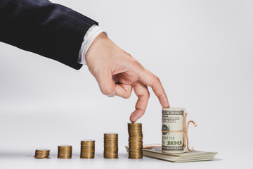 Finger of businessman walking up Growing Money graph symbol of a successful profitable transaction. Stack of gold coins as a symbol of business success or successful finance and Investment concept