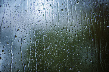 Rain drops on window glasses surface with bokeh background.