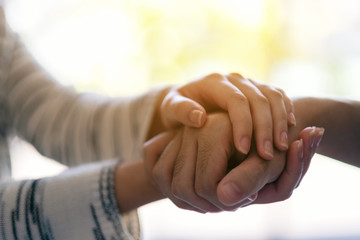 Wall Mural - A man and a woman holding each other hands for comfort and sympathy