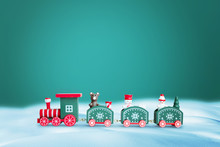 Green Train In Snow. Copy Space Above On Green Background For Greeting Text. Christmas, New Year Greeting Card Concept.