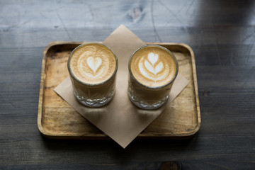 Wall Mural - .Two cup of cappuccino art on a wooden table. Bokeh background.