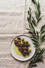 Several Varieties Of Fresh Olives In Different Ceramic Plates On An Old Vintage Gray Napkin Tablecloth Table Background. Natural Product Concept. Rustic Vintage Set Of Cutlery. Top View, Copy Space.