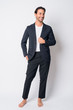 © Ranta Images - Full body shot of happy Hispanic businessman thinking
