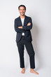 © Ranta Images - Full body shot of happy Hispanic businessman smiling with arms crossed
