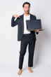 © Ranta Images - Full body shot of shocked Hispanic businessman showing and pointing at laptop