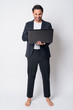 © Ranta Images - Full body shot of happy Hispanic businessman using laptop
