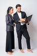 © Ranta Images - Full body shot of multi ethnic business couple using laptop together