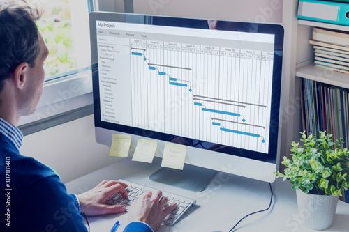 Fotomural Project manager working on Gantt chart schedule to create planning with tasks an