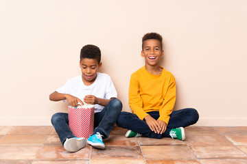 Wall Mural - Happy African American brothers  holding popcorns