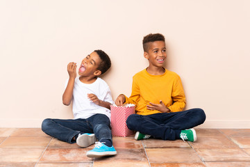 Wall Mural - Happy African American brothers  holding popcorns