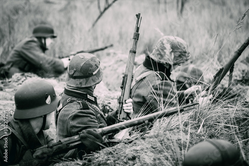Fotografía Wehrmacht soldiers in the trenches with rifles on the black white image
