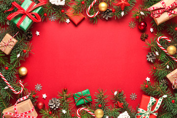 christmas or happy new year composition. frame made of fir branches, gift boxes and holiday decorati