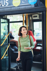 Wall Mural - Female traveler going off the bus at terminal