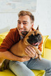 © LIGHTFIELD STUDIOS - Smiling man looking at camera and hugging french bulldog