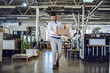 © Dusan Petkovic - Smiling caucasian bearded graphic engineer in shirt and tie walking in printing shop and relocating box. In background are printing machines.