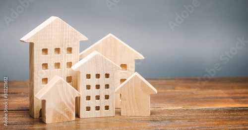 Miniature wooden houses. Real estate. City. Agglomeration and urbanization. Market Analytics. Demand for housing. Rising and falling home prices. Population