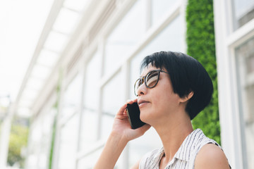 Canvas Print - Asian woman sit and talk on cellphone