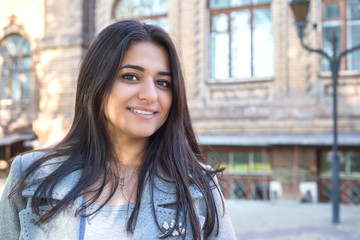 portrait of a beautiful young indian girl, smiling. Against the background of an old building