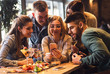 © Zoran Zeremski - Group of young friends having fun in restaurant talking, laughing while dining at table and making selfie.