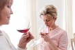 © moodboard - Mature women drinking wine while standing at home