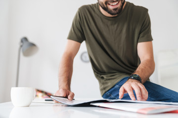 Sticker - Cropped image of young smiling caucasian man reading documents