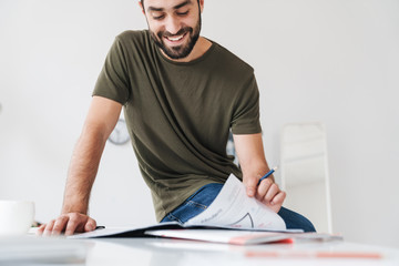 Sticker - Image of cheerful caucasian man reading documents and making notes