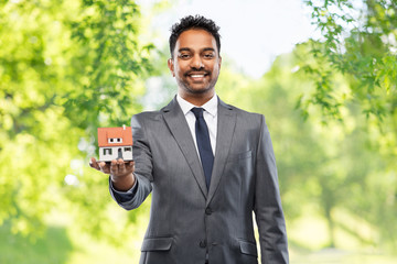 Sticker - real estate business and people concept - indian man realtor with house model over green natural background