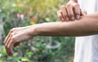 © mintra - The women are scratching arms herself from itching in healthy concept on nature background.
