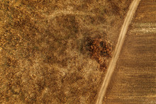 Aerial View Of Dusty Dirt Road Through Grassy Plain Landscape