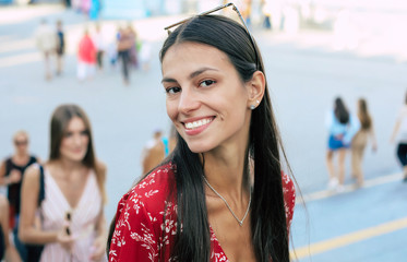 Wall Mural - Modern girl. Close up photo of a gorgeous girl with long jet-black hair, who is looking in the camera with her head slightly turned to the left and smiling broadly.