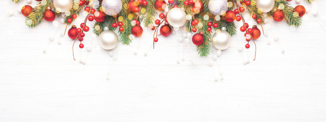 classic christmas composition with fir branches and white and red baubles on white wooden background