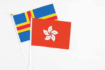 Hong Kong and Aland Islands stick flags on white background. High quality fabric, miniature national flag. Peaceful global concept.White floor for copy space.