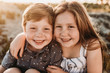 © Cavan Images - Portrait of young redheaded freckled siblings smiling during sunset
