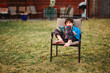 © Cavan Images - A happy boy reads a book barefoot in backyard in cool weather