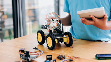 Boy with tablet pc computer programming electric toys and buildi