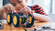 © Cavan Images - Concentrated boy creating robot at lab.